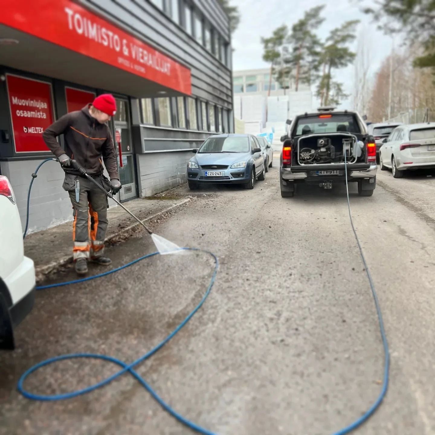 Työntekijä puhdistaa kiinteistön piha-aluetta